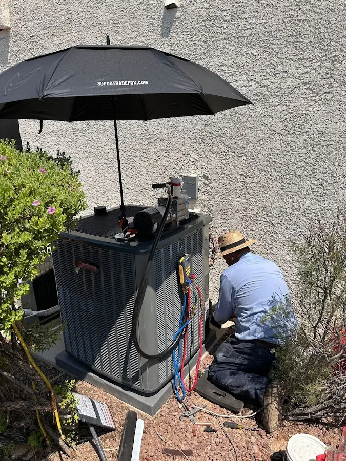 HVAC technician performing outdoor AC maintenance in Litchfield