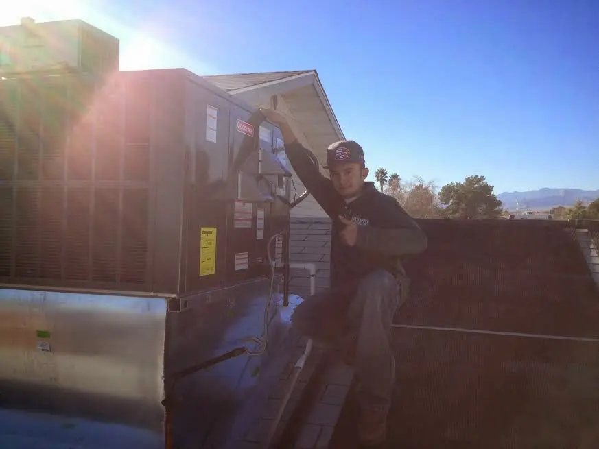 HVAC technician performing Heat Pump Repair on a rooftop unit in Litchfield